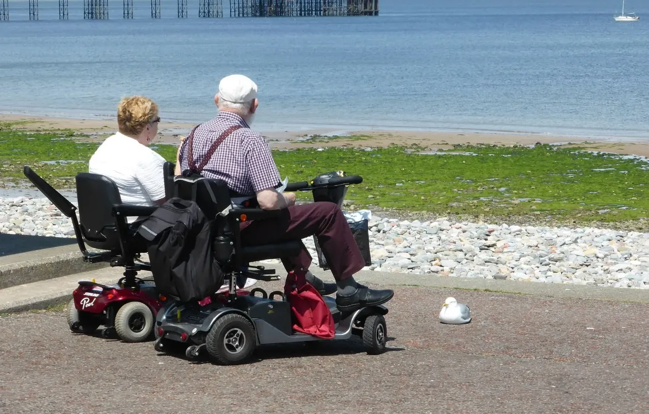 Senior rijdt op een scootmobiel door een ruime, groene woonwijk in Tilburg