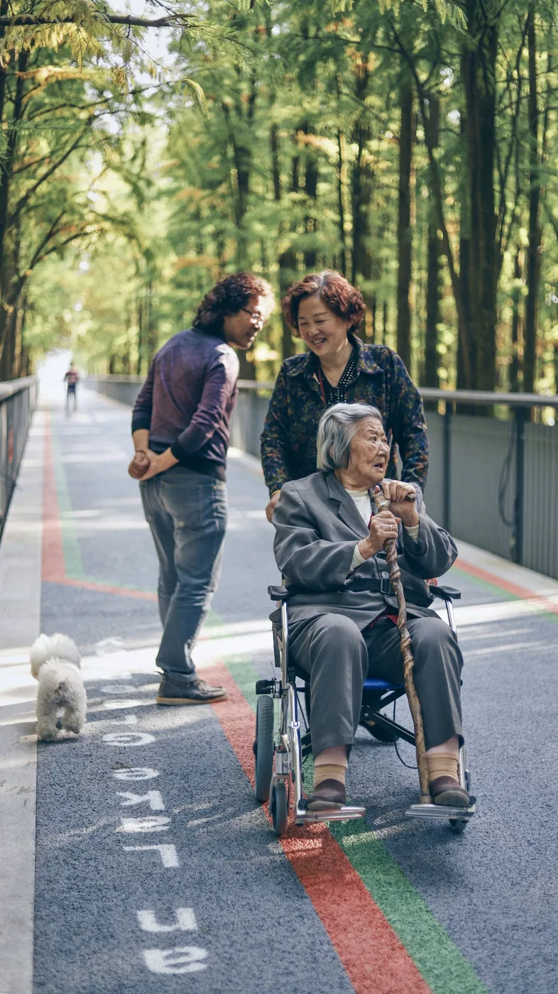 Familie met een oudere vrouw op een zonnig parkpad